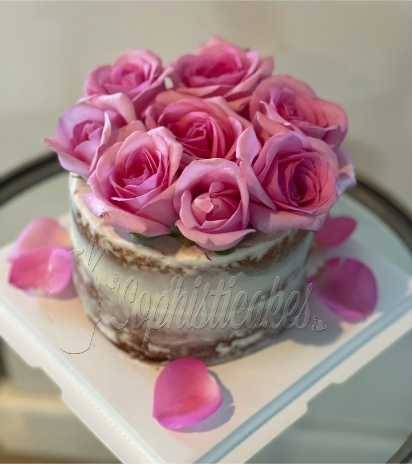 Queque estilo naked cake decorado con rosas rosadas