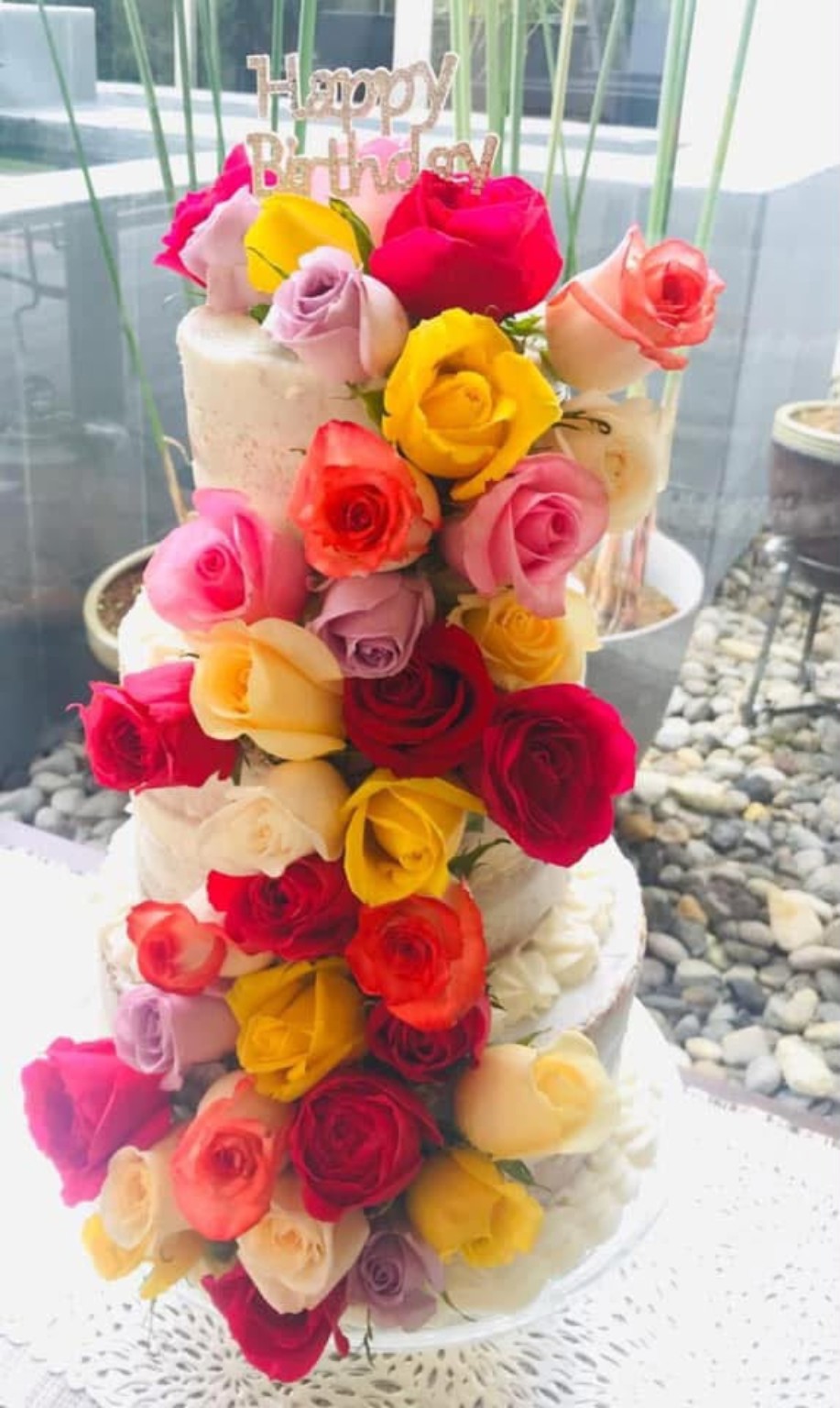 Queque de cumpleaños decorado con flores multicolor en cascada